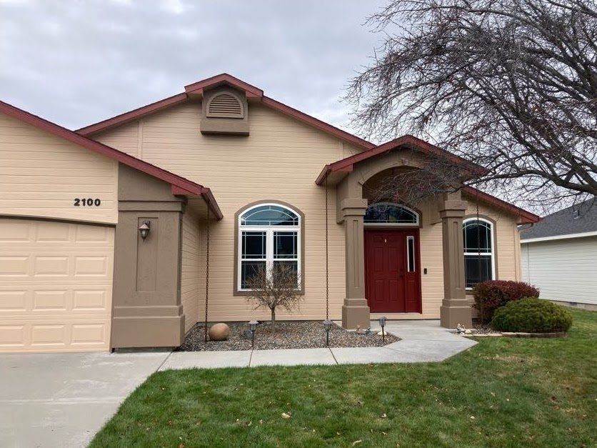 Real Busy Bee exterior painting photo: tan home with dark trim and red door